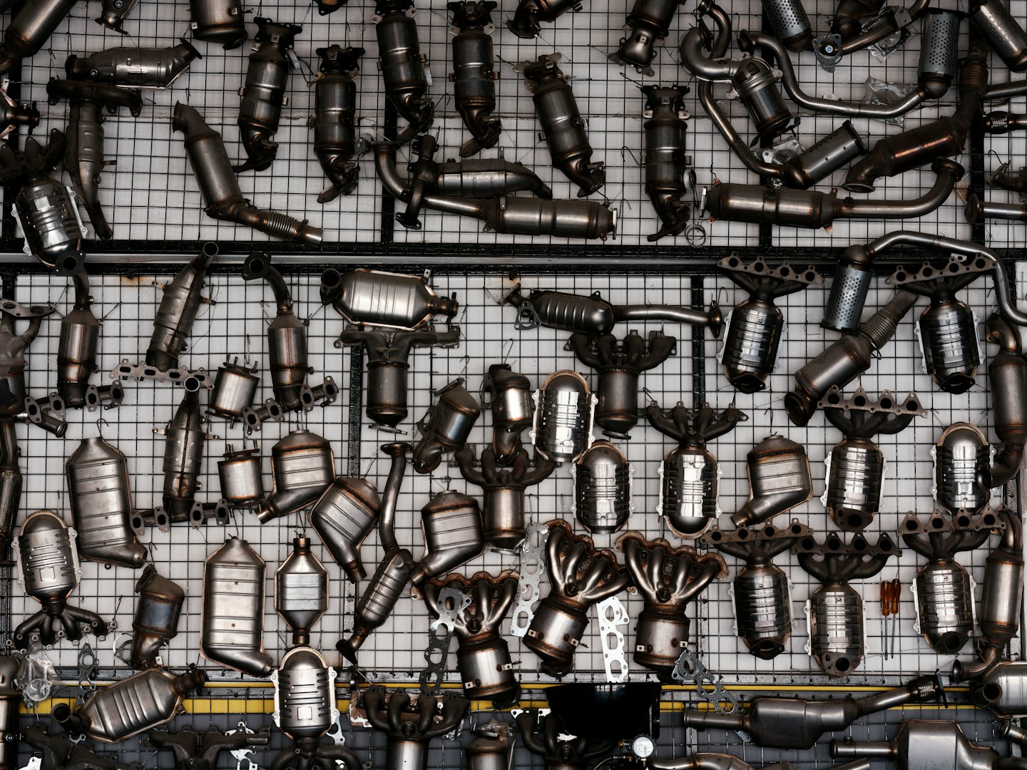 Convertitori catalitici e collettori di scarico per auto usati disposti a griglia.