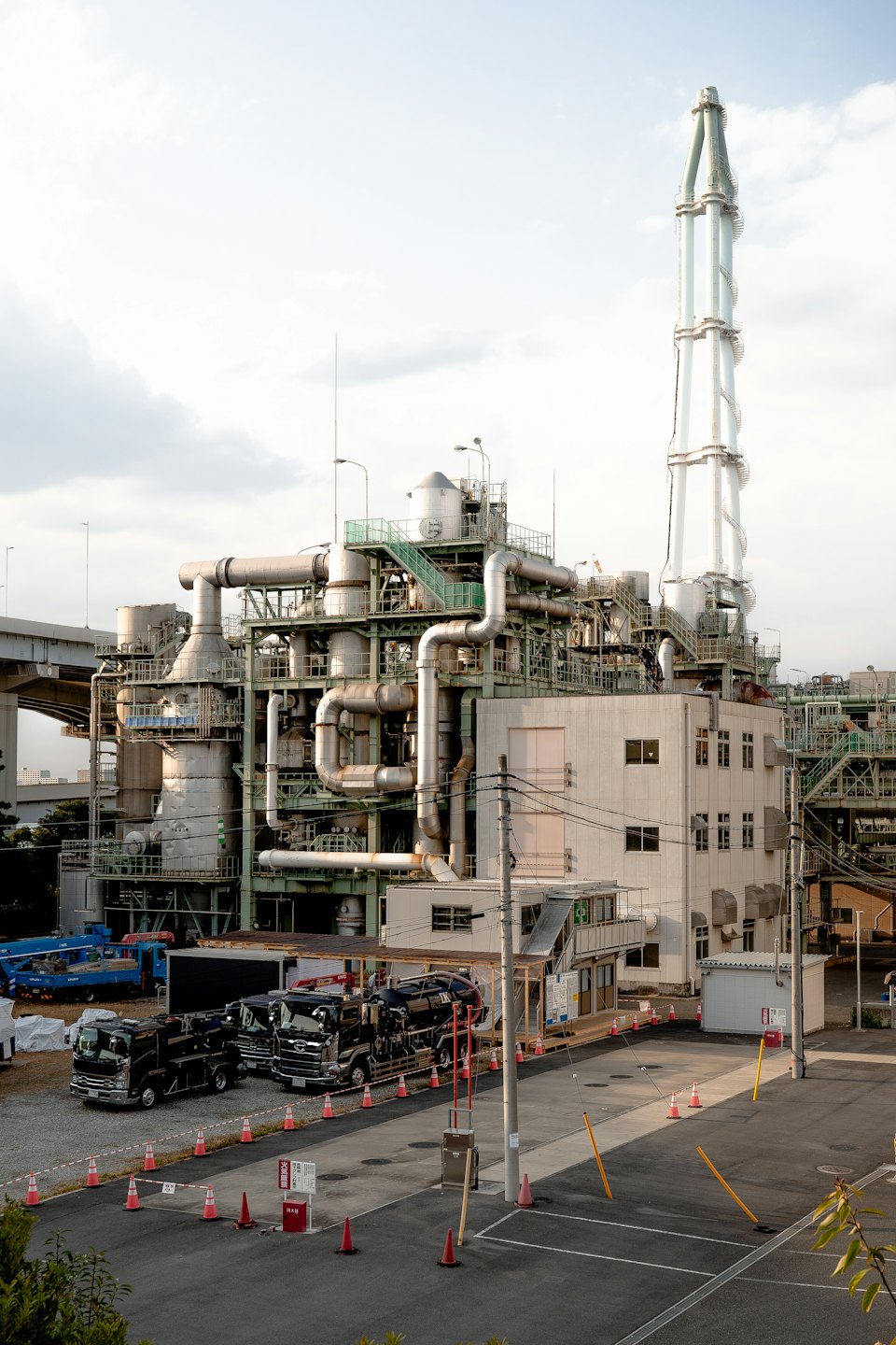 Impianto industriale con tubature complesse e ciminiere alte.