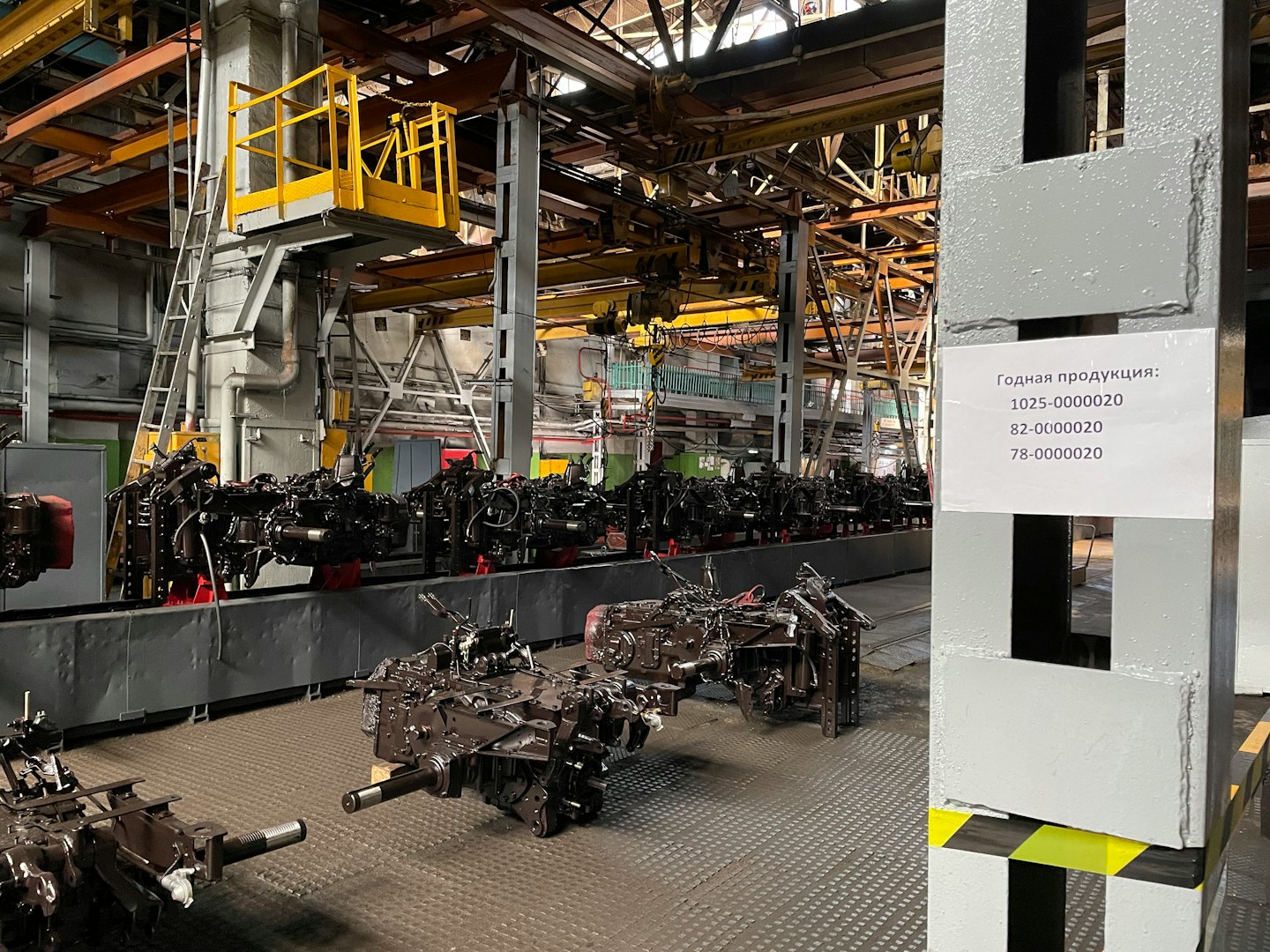 Componenti di macchinari pesanti su un nastro trasportatore di linea di assemblaggio in fabbrica.
