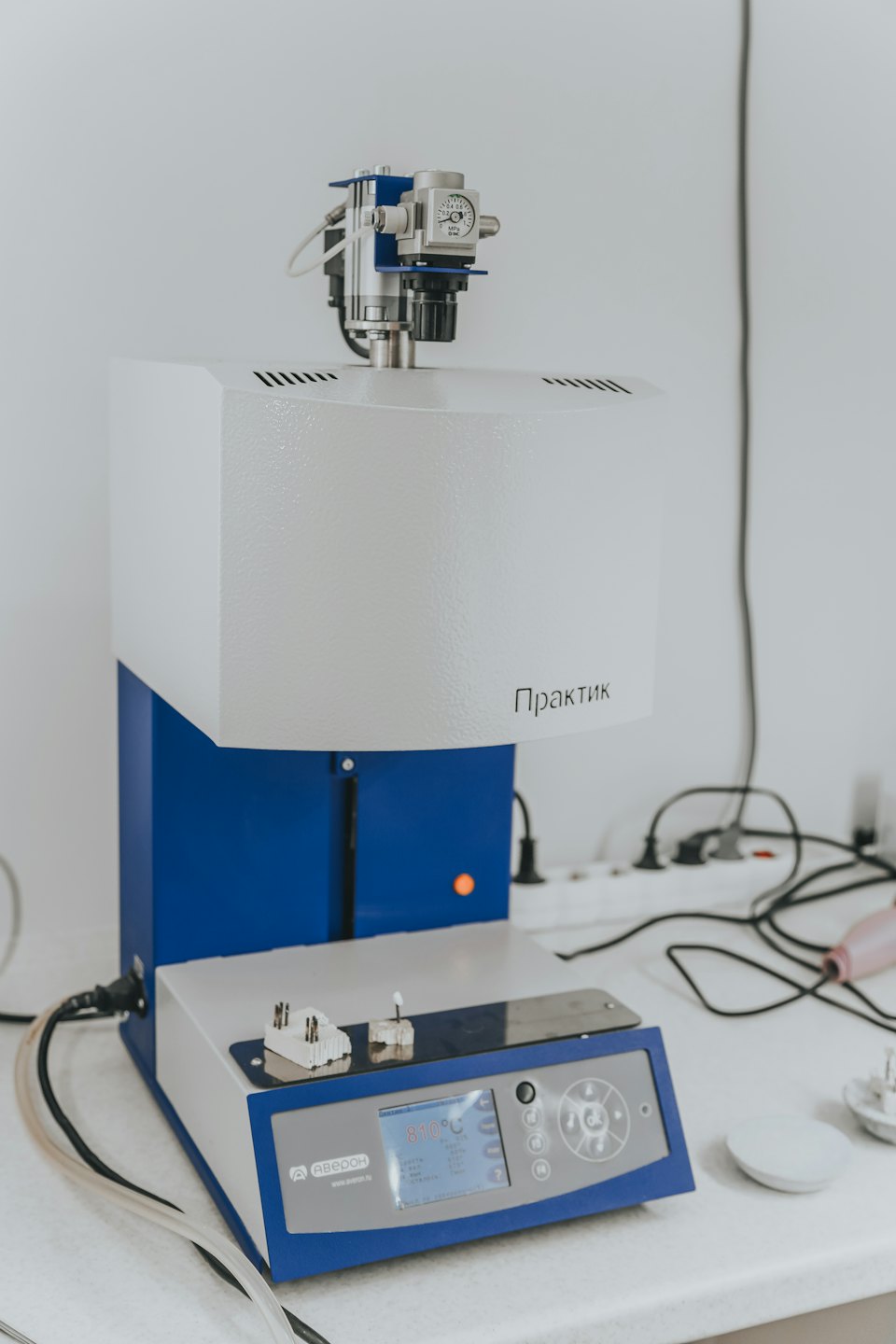 Forno da laboratorio con temperatura visibile su un bancone bianco.